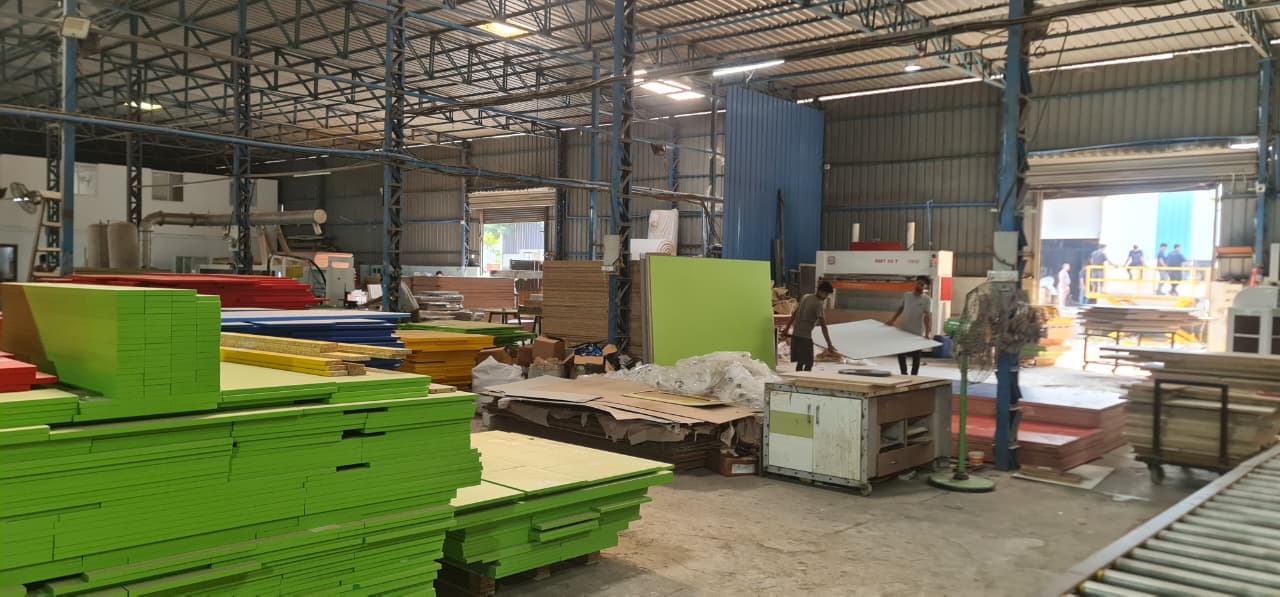 The OutDo factory floor near Pune, with cut panels stacked by order and the machines running